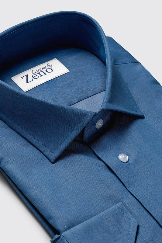 Snipp, søm og knappedetaljer på en elegant denimskjorte. Snippen er cut away og knappene er lyse og elegante. Foto