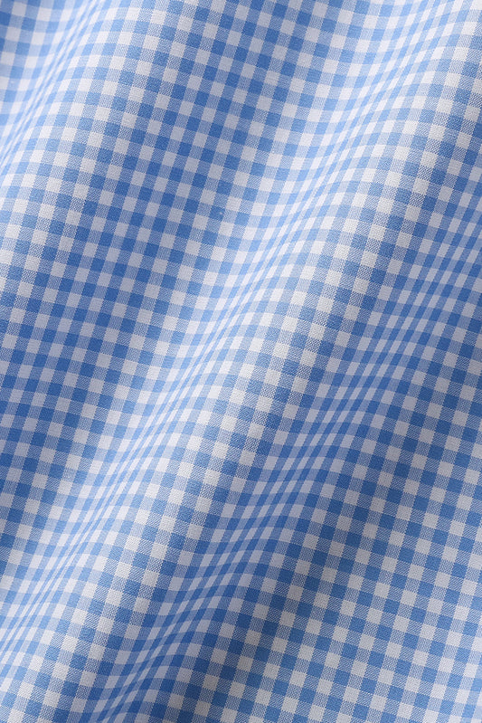 Stoffdetaljer av skjortestoff i klassisk lyseblått rutemønster. Stoffet bølger seg elegant og gir et eksklusivt preg. Foto