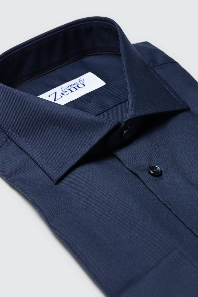 Stoff, snipp og sømdetaljer på en klassisk og elegant marineblå dresskjorte med cut away-snipp og knapper i ton-i-ton farge. Foto