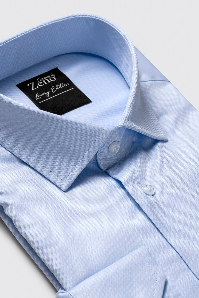 Snipp og strukturdetaljer på lyseblå klassisk herreskjorte med
fiskebenstruktur. Cut away-snipp og elegante knapper i perlemor-look. Foto