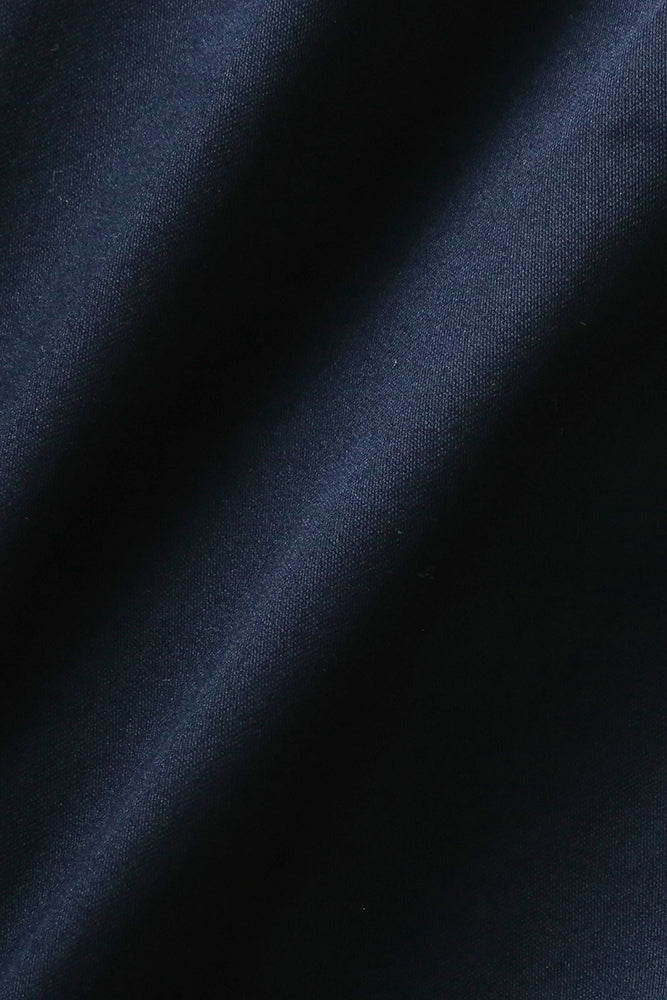 Stoffdetaljer på herreskjorte i marineblå premium twill med enkel mansjett. Stoffet bølger seg lett, som viser dets mykhet og eleganse. Foto