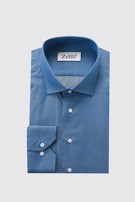 Front av elegant og klassisk denimskjorte med cut away-snipp og lyse knapper i perlemor-look. Foto