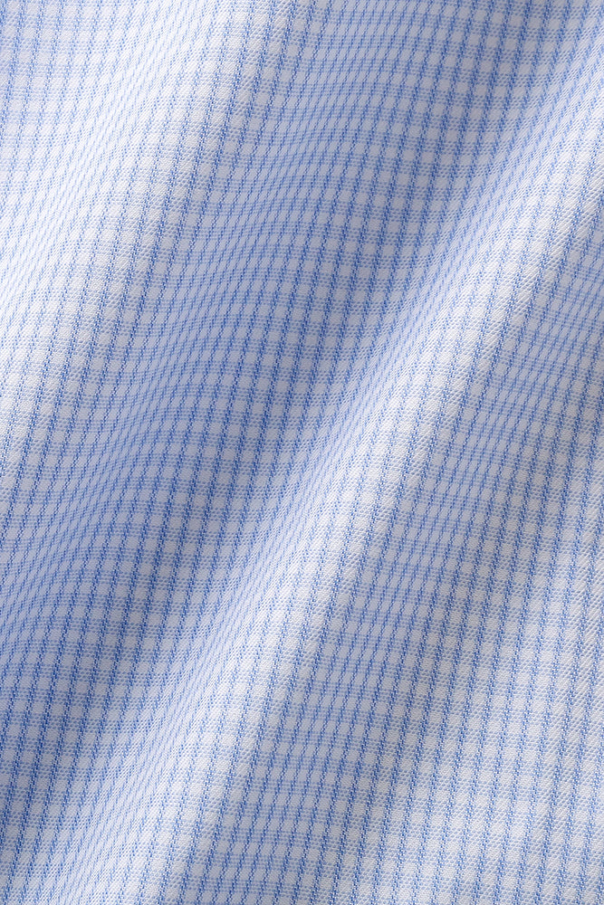 Stoffdetaljer av skjortestoff med lyseblå elegante små ruter. Stoffet bølger seg elegant og gir et eksklusivt preg. Foto